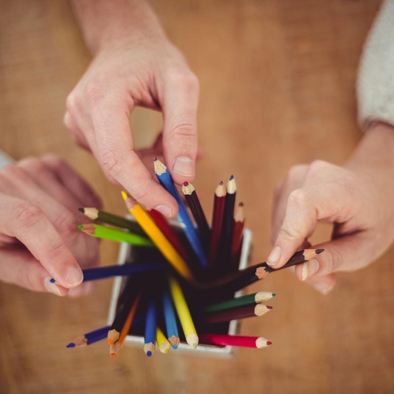 creative-team-choosing-different-coloured-pencils-PMSUVPX-pr3offk4q7dddu1w8zj8ddmywcfmcj35dyzic0x4xs